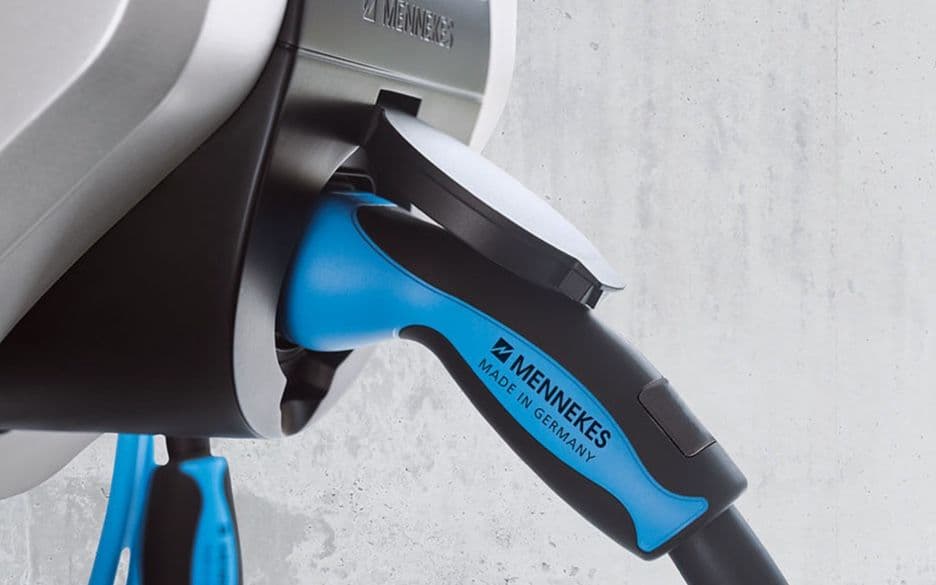 Close-up of a charging plug inserted into a wallbox for electric vehicles.